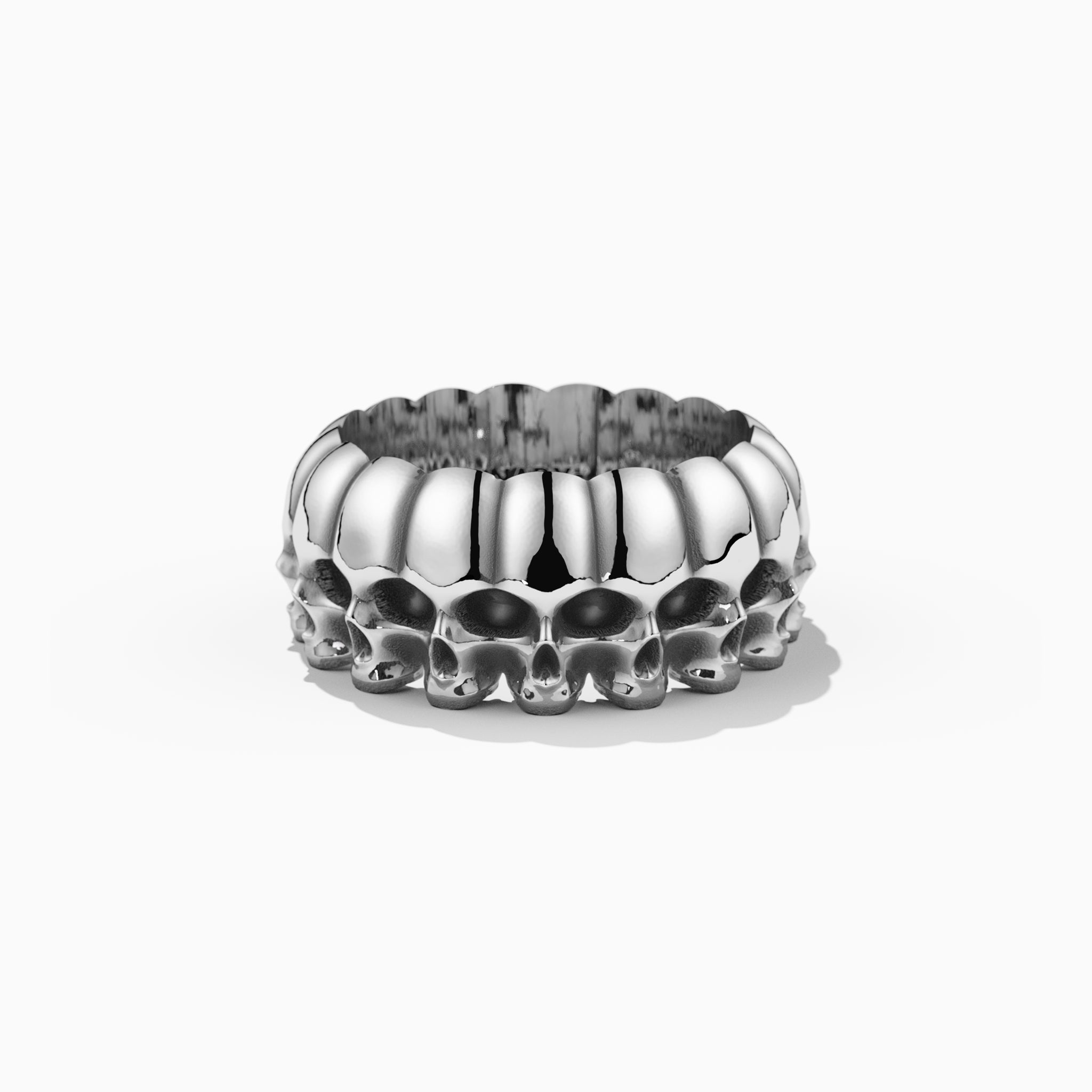 ORDINARYsterling sterling silver row of skulls ring on a white background